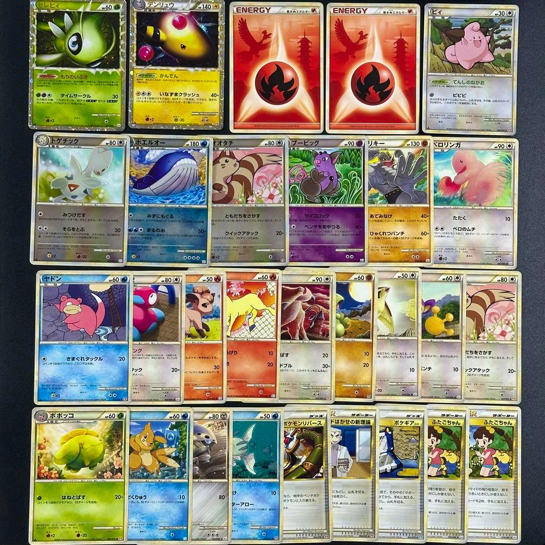 A flat lay of Pokémon trading cards (bulk set) arranged in rows on a dark background, including holographic and regular cards.