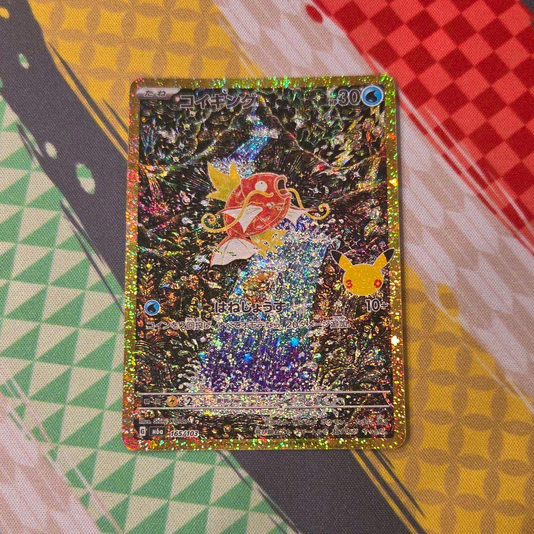 Front of the ポケモンカード　コイキングAR 復刻版 trading card with holographic foil placed on patterned fabric.