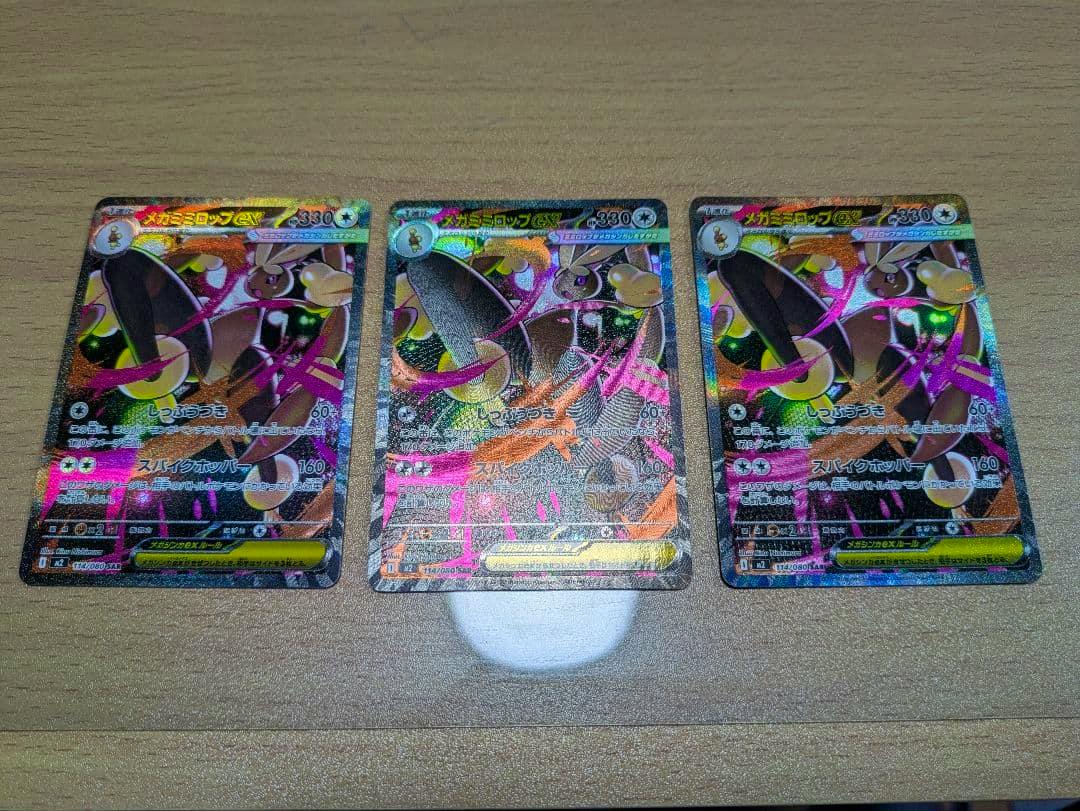 Three ポケモンカード メガミミロップex SAR trading cards shown face-up on a wooden surface.