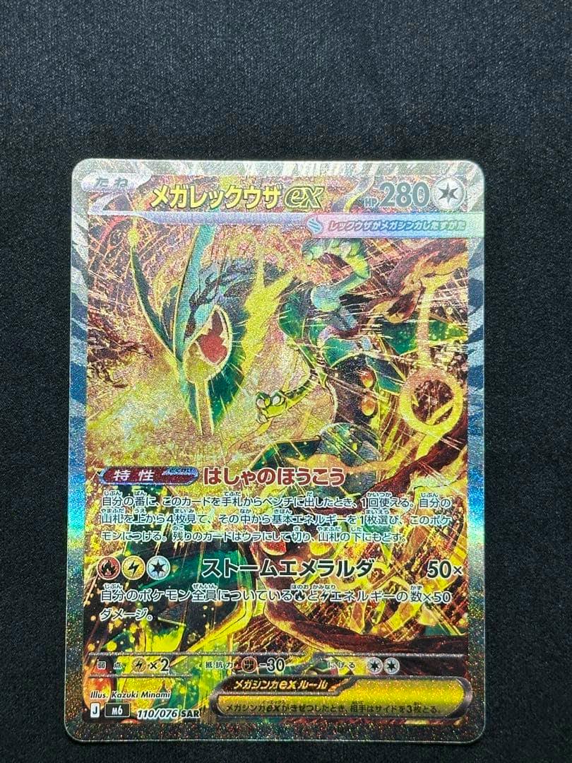Holographic Japanese Pokémon trading card メガレックウザEX SAR photographed on a dark background.