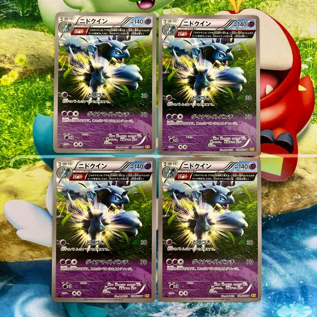 Four front-facing Japanese Nidoqueen Pokémon trading cards arranged in a two-by-two grid on a playmat.