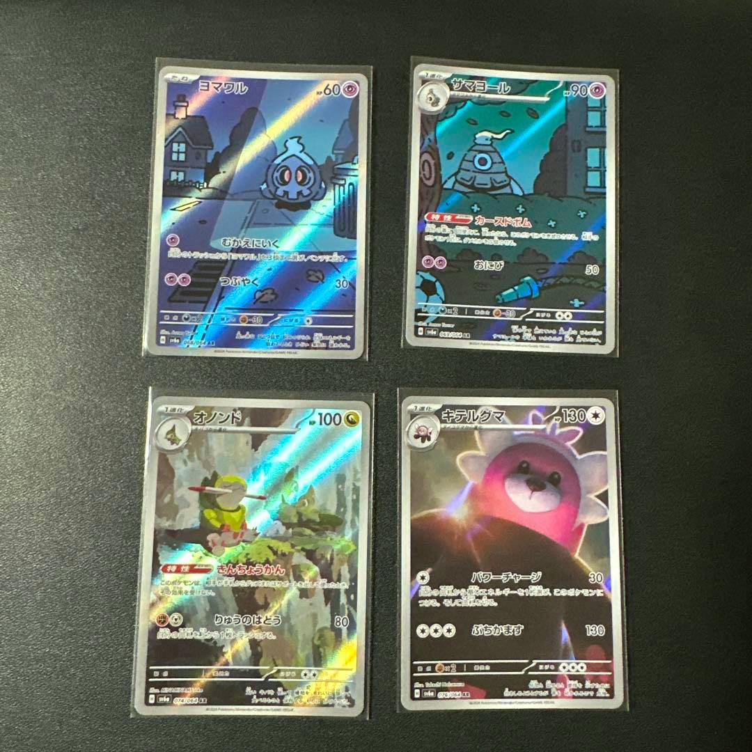 Four Pokémon trading cards from the ナイトワンダラー AR set arranged on a dark surface.