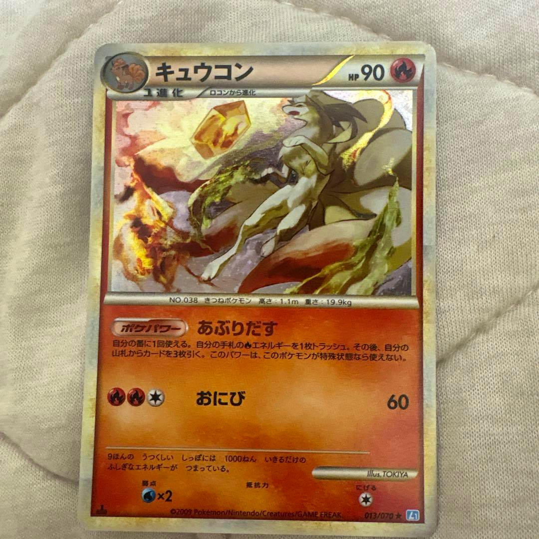 Front view of the Pokémon trading card ポケモンカード キュウコン showing the full card on a fabric background.