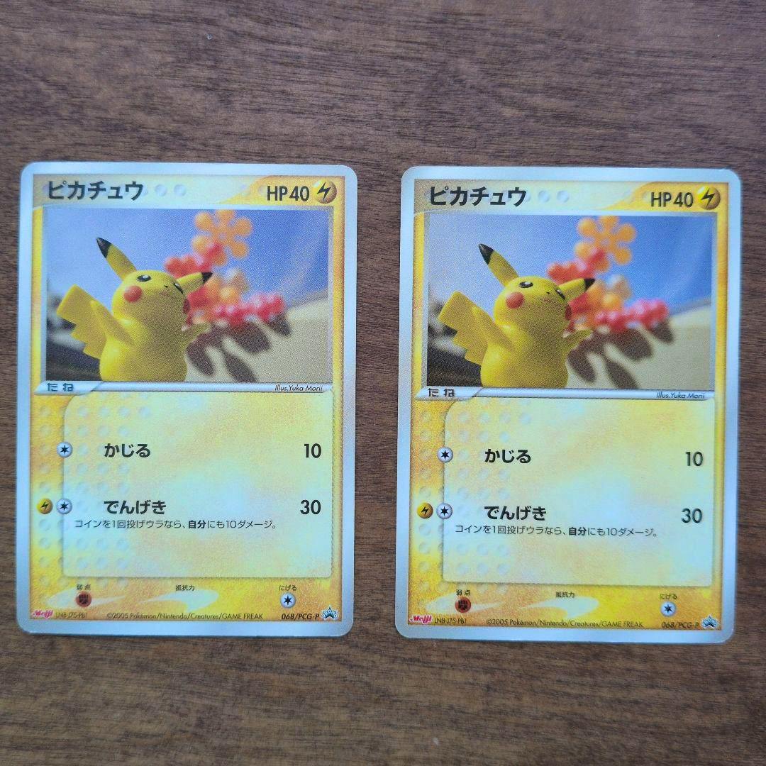 Front of two Pikachu 068/PCG-P Meiji 2005 promo trading cards on a wooden surface.