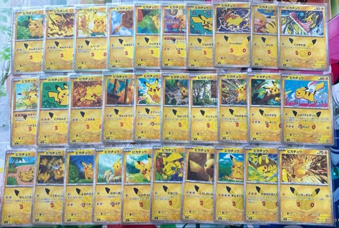 Photo of Pikachu 30th anniversary Pokémon trading cards arranged in rows showing card artwork and text.