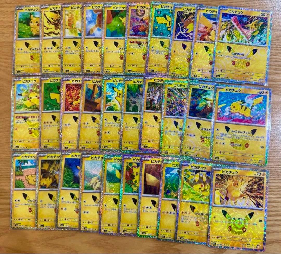 Photo of many Pikachu trading cards from the 30th anniversary set arranged in rows on a wooden surface.