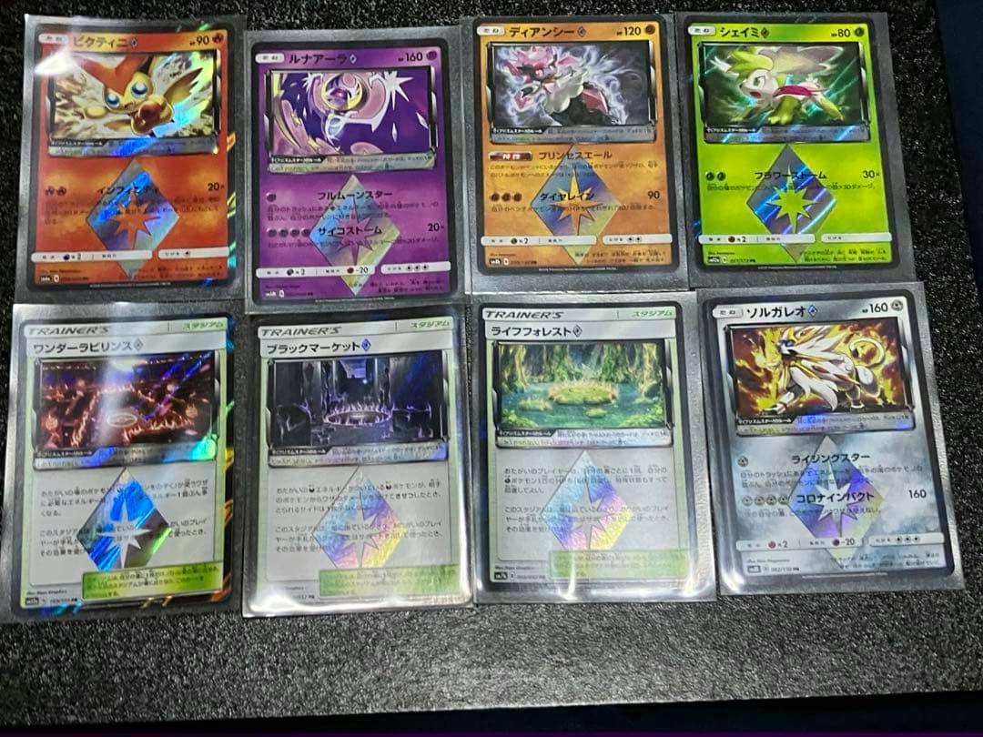 Eight Pokémon Prism Star trading cards in protective sleeves arranged in two rows of four on a dark surface.