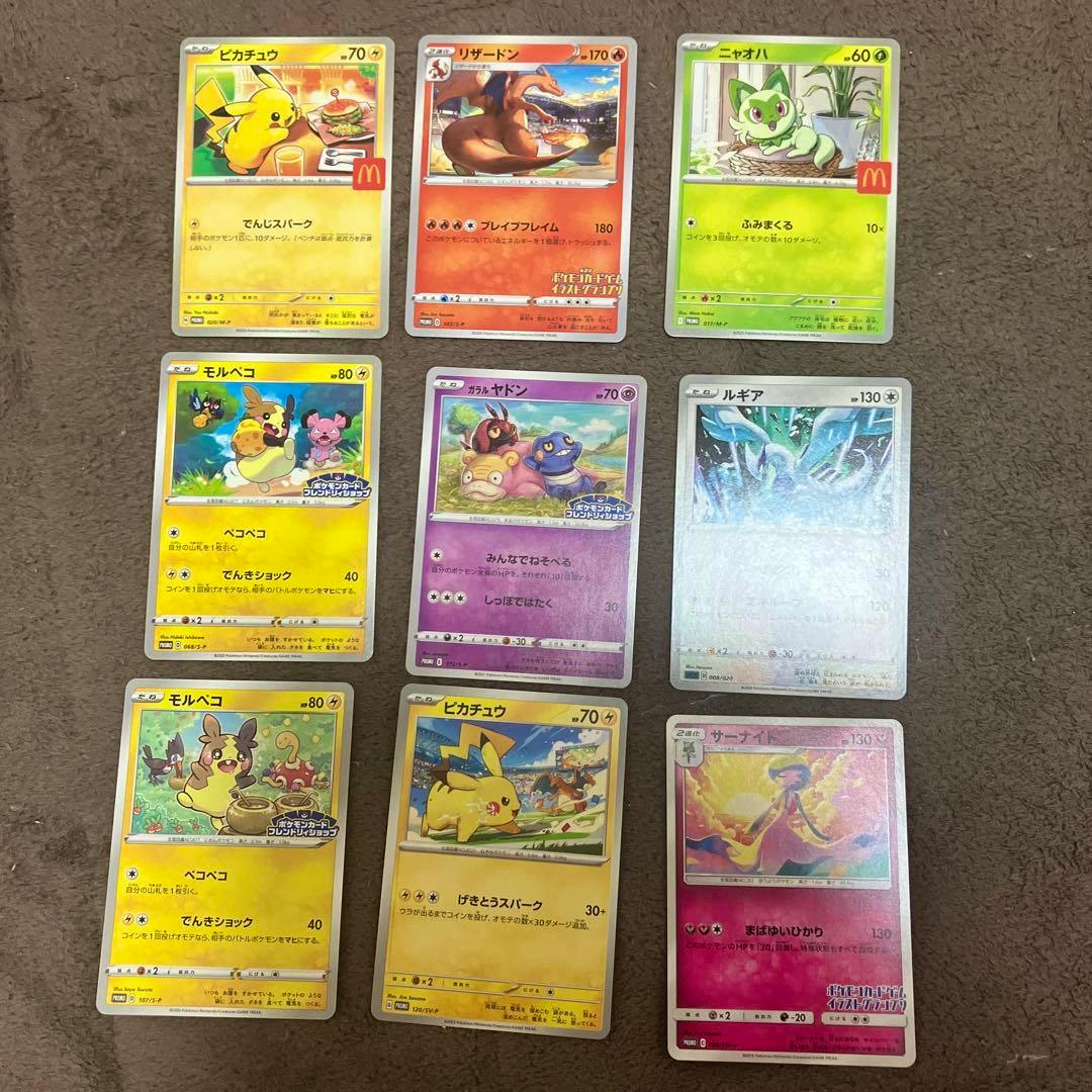 Nine Pokémon trading cards arranged in a 3x3 grid on a brown surface.
