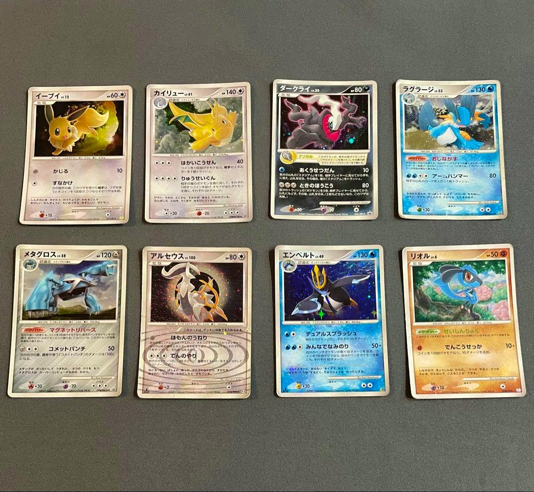 Eight Pokémon trading cards arranged in two rows on a gray surface, shown as a grouped lot.