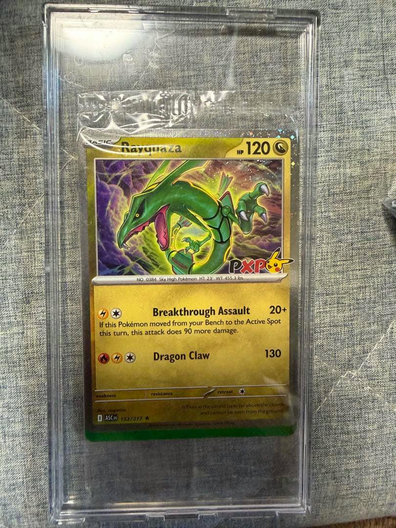 Rayquaza PXP promo Pokémon trading card shown inside a clear plastic slab on a gray fabric background.