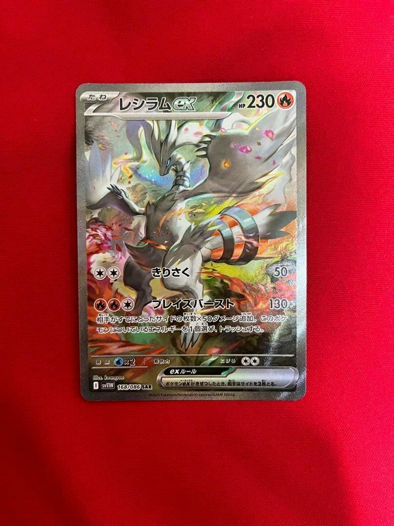 Photograph of the Reshiram ex (レシラムex) Pokémon trading card showing the card artwork and Japanese text on a red background.