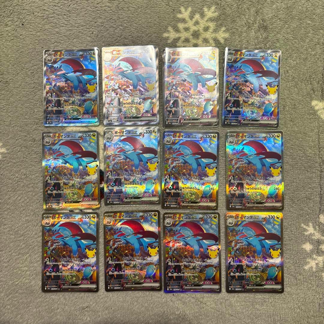 Twelve holographic Pokémon trading cards labeled ボーマンダex arranged in a 3x4 grid on a carpet.