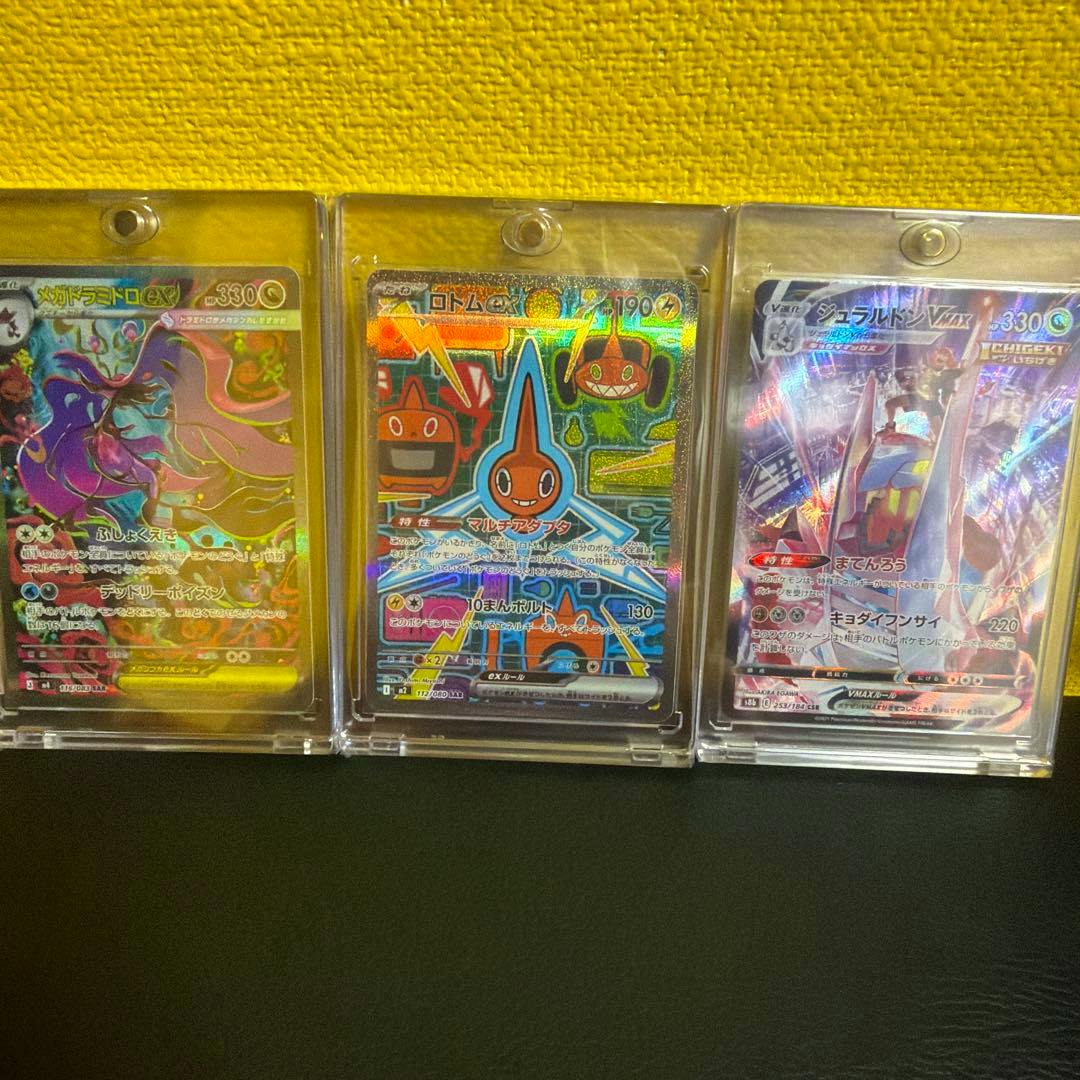 Three Pokémon trading cards (SAR/CSR 3-card set) shown in clear protective holders side by side against a yellow background.