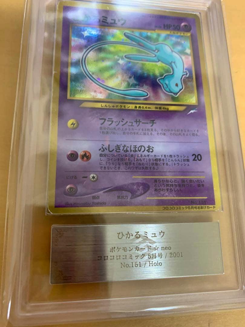 Holographic Japanese ひかるミュウ (Shining Mew) Neo trading card shown front-facing in a clear protective slab with a metal identification plate visible.