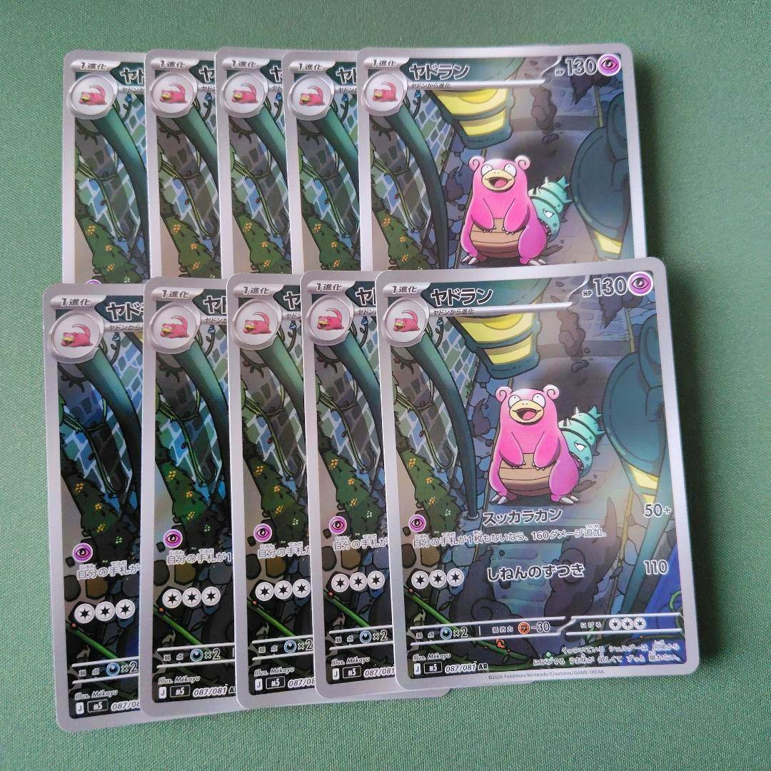 Ten Pokémon trading cards of ヤドラン (AR 087/081) arranged on a green background showing the card fronts.
