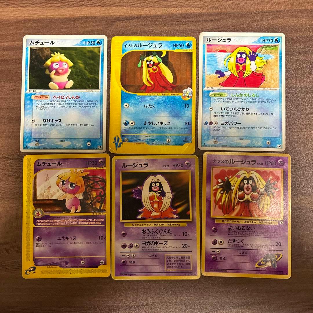 Six Japanese Pokémon trading cards (ムチュール and ルージュラ) laid out on a wooden surface showing the card fronts.