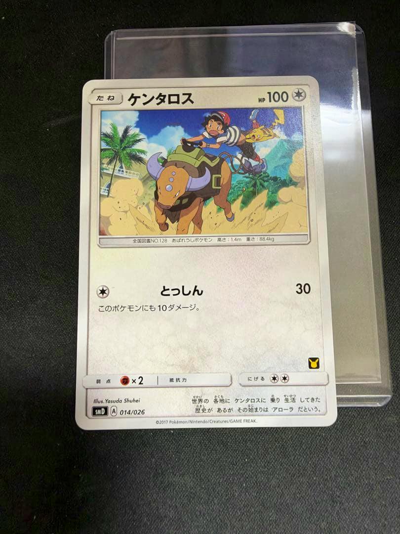 Photograph of the ケンタロス (Tauros) Pokémon trading card 014/026 in a protective sleeve on a dark surface.