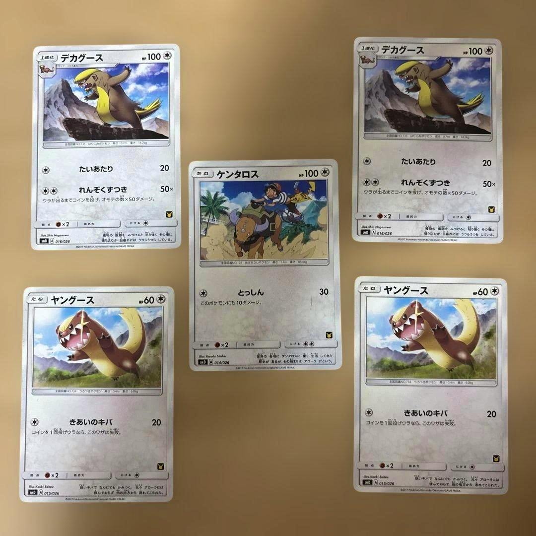 Five Pokémon trading cards (ケンタロス, ヤングース, デカグース) arranged on a beige background.