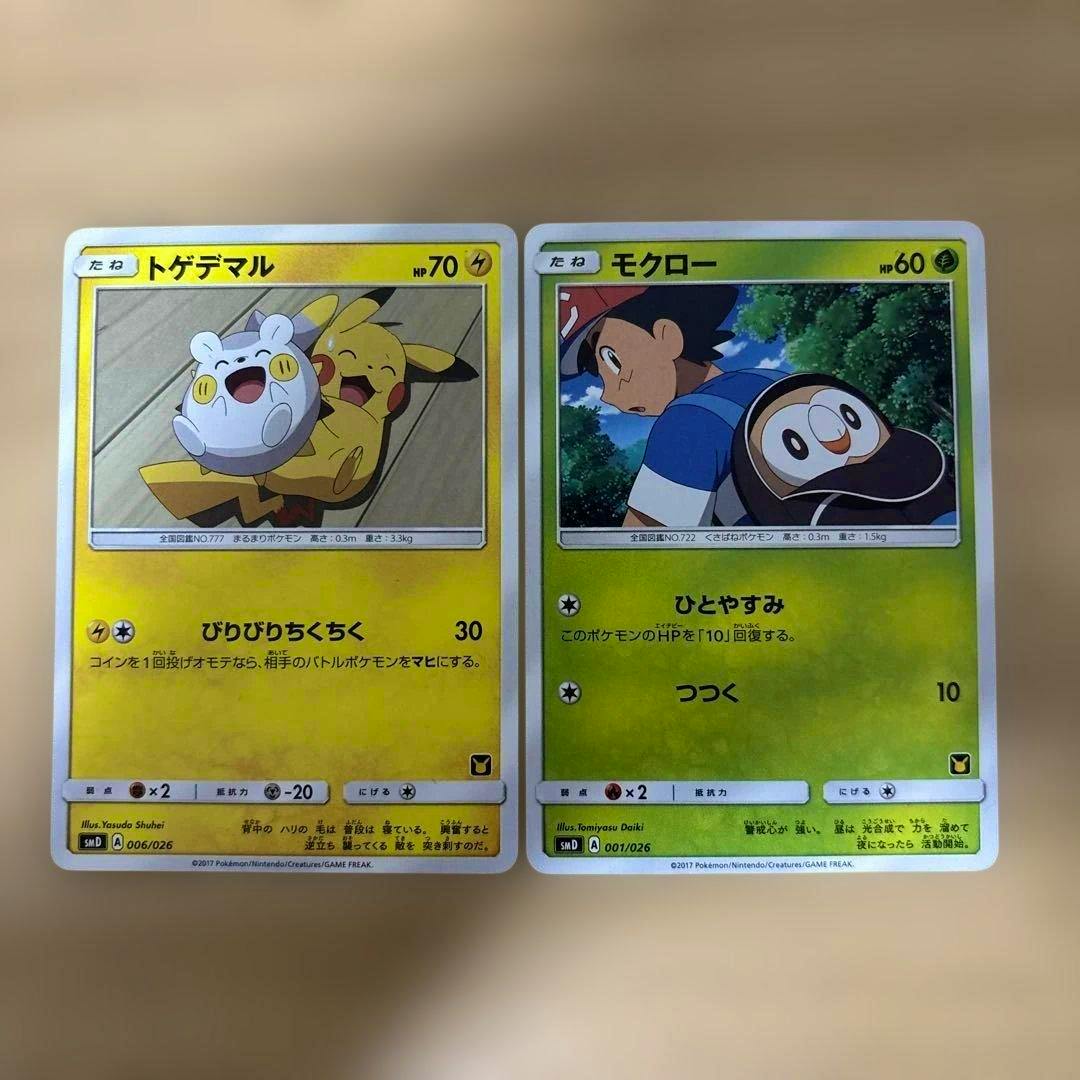 Two Pokémon trading cards showing トゲデマル (left) and モクロー (right) placed side by side on a flat surface.