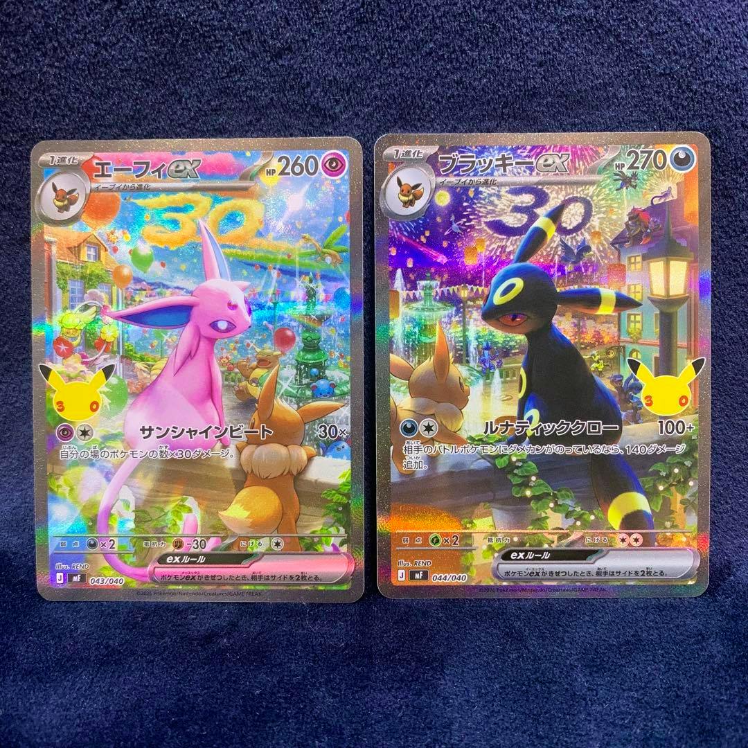 Front-facing photo of two Pokémon trading cards: エーフィex (Espeon ex) on the left and ブラッキーex (Umbreon ex) on the right, both holo, on a dark blue background.