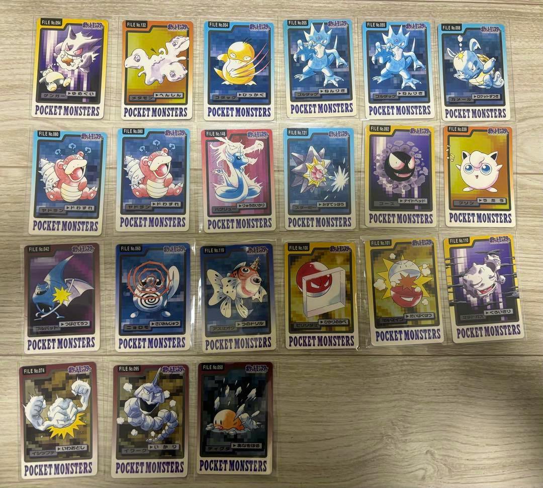 Photo of multiple Pocket Monsters (Pokémon) Carddass cards arranged on a wooden surface.