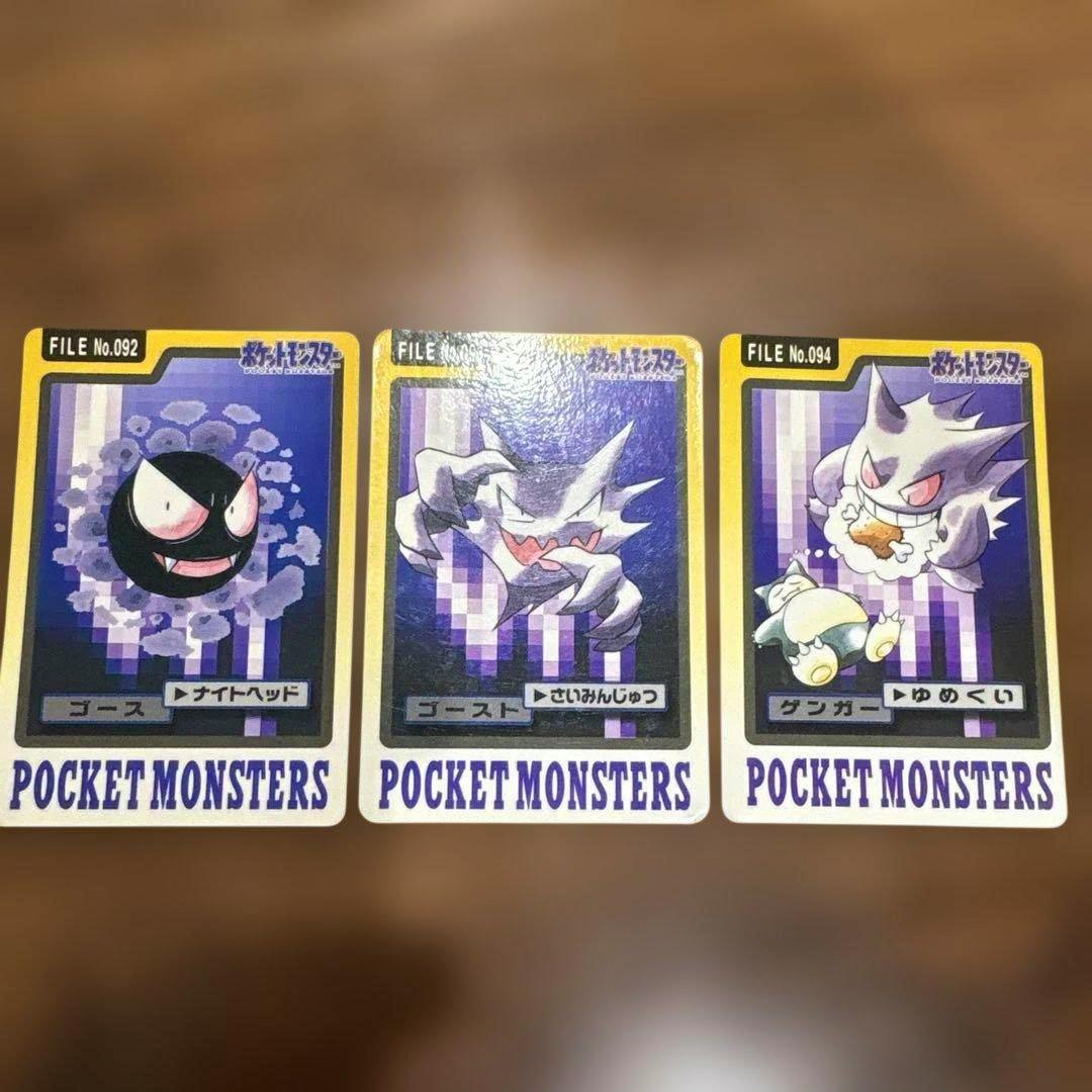 Three Pocket Monsters photocards (ゴース, ゴースト, ゲンガー) laid side by side on a wooden surface.