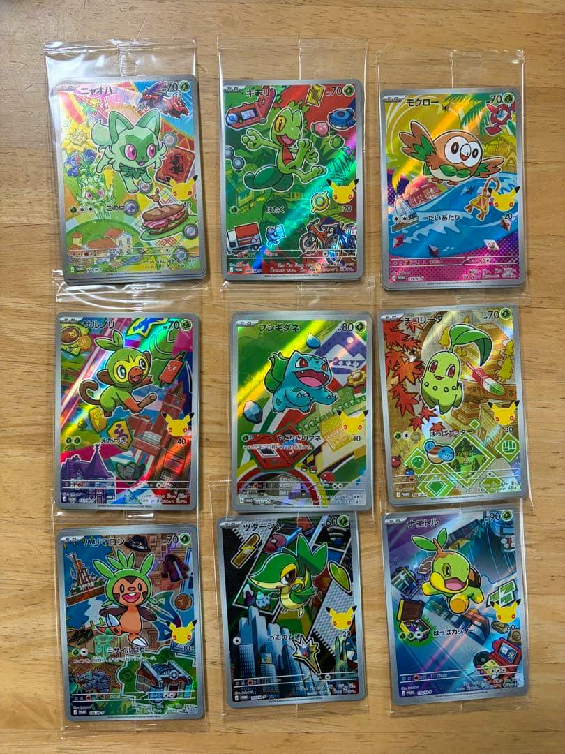 Nine Pokémon trading cards in protective sleeves arranged in a 3×3 grid on a wooden table.