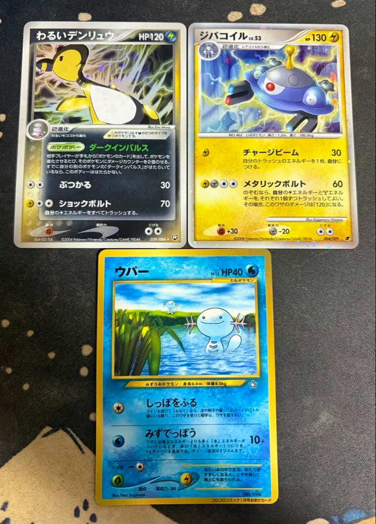 Three Pokémon trading cards — わるいデンリュウ, ジバコイル, and ウパー — shown face-up on a dark background.