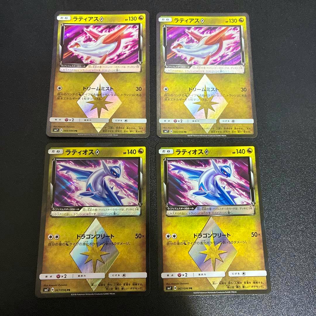 Fronts of four Pokémon trading cards (Latias and Latios Prism Star) arranged on a dark surface.