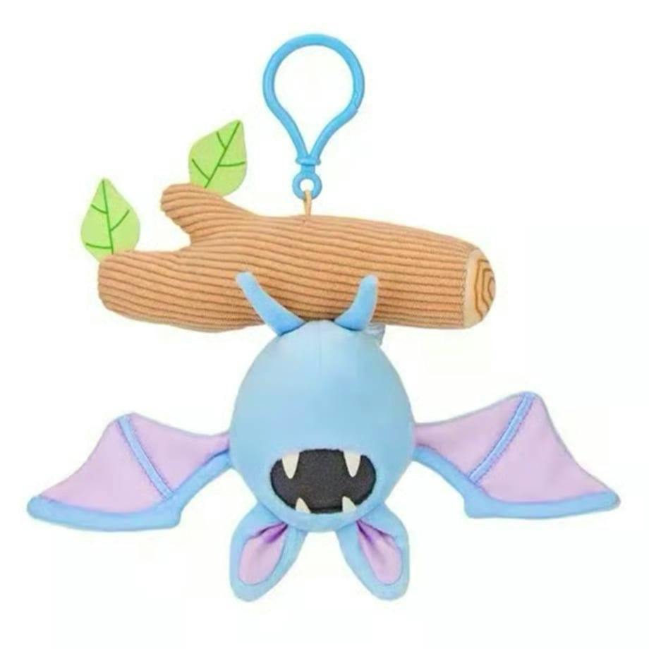 Blue Zubat plush keychain hanging upside down from a brown fabric log with a blue plastic clip, showing its wings and open mouth.
