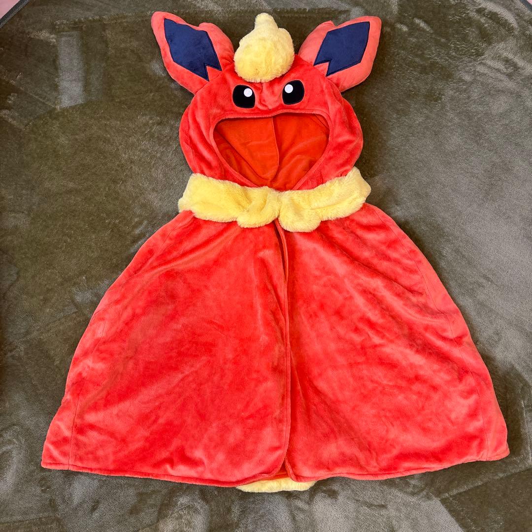 Front view of a Flareon hooded women’s poncho laid flat, showing the hood with ears and face and a yellow collar.