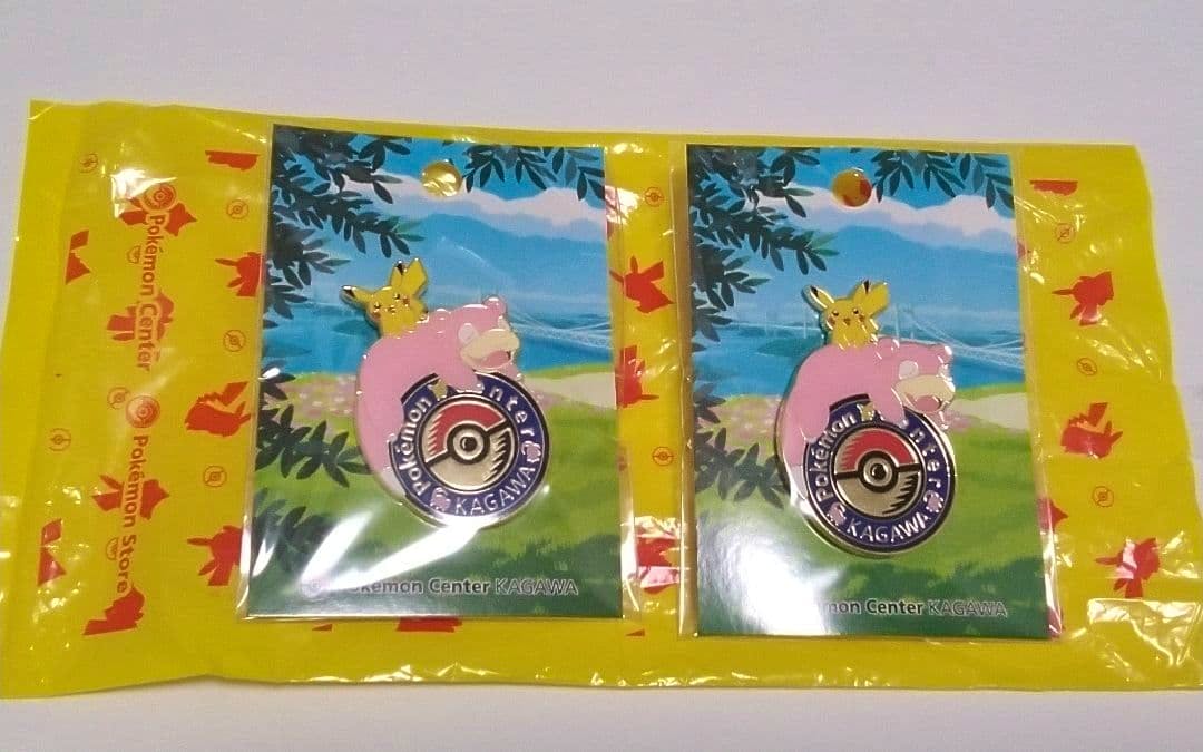 Two Pokémon Center Kagawa enamel logo pins featuring Slowpoke with Pikachu on display cards inside plastic packaging.