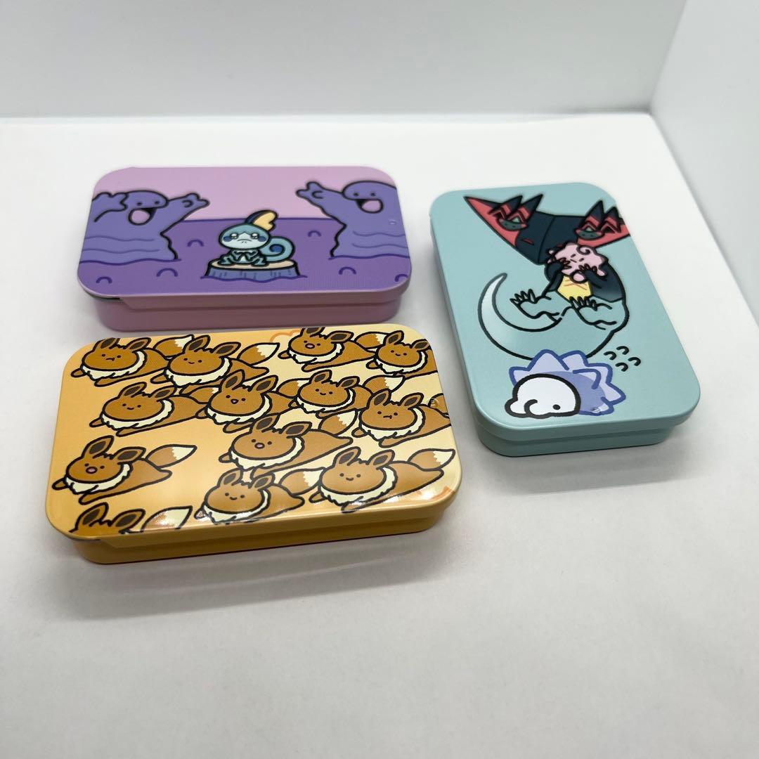 Three small aluminum collectible Pokémon tins with different character designs shown on a white surface.