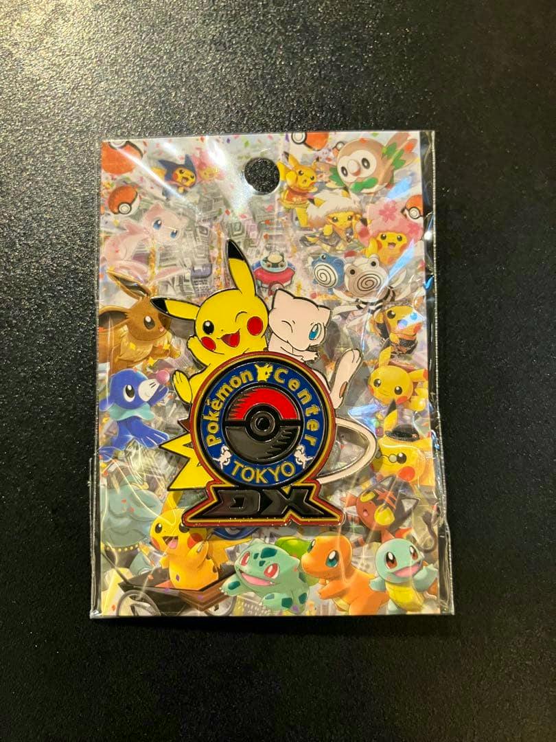 Packaged Pokémon Center TOKYO DX logo pin with Pikachu and Mew on a colorful backing card.