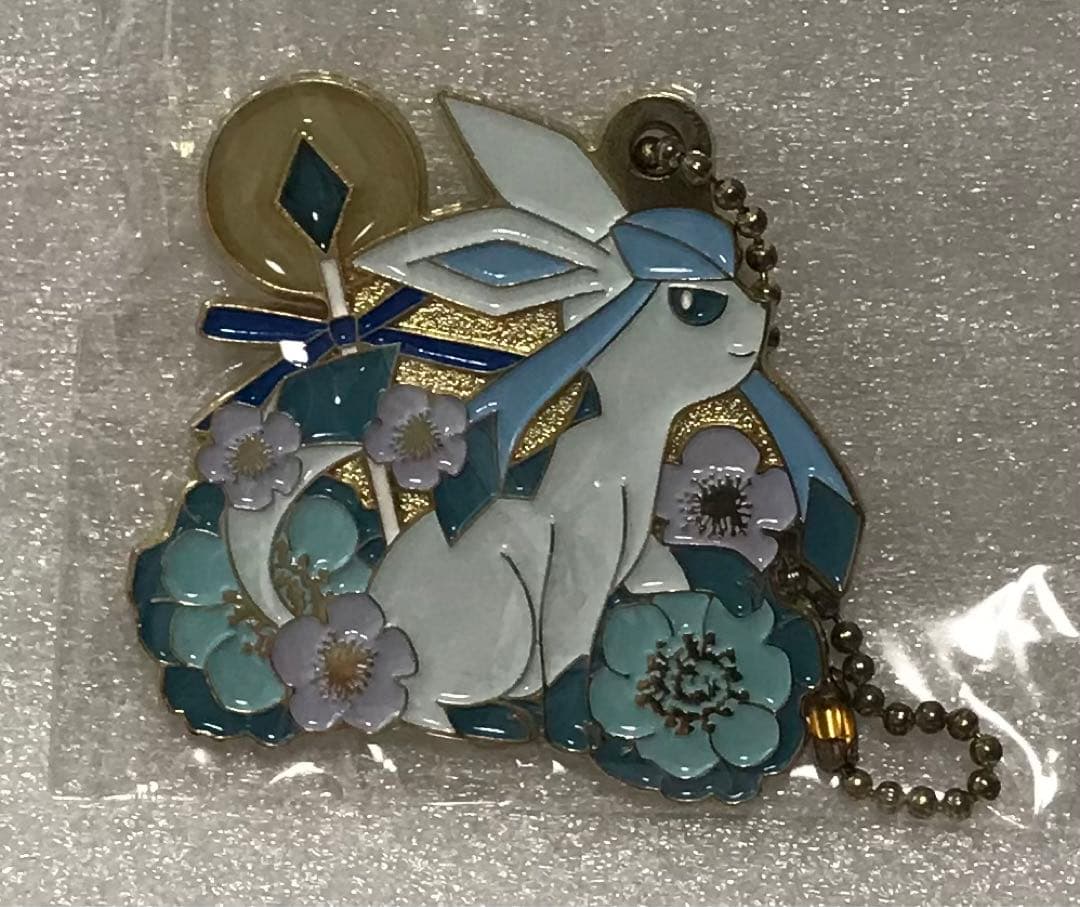 Front view of the metal Glaceon keychain charm with floral decorations and an attached ball chain.