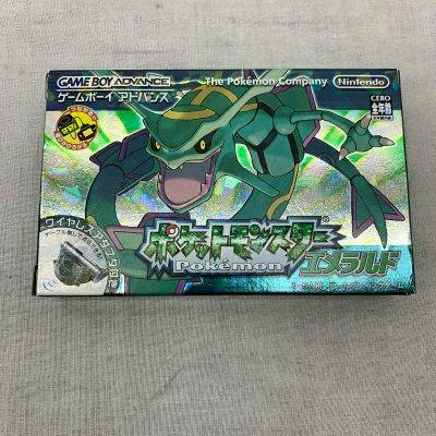 Photograph of the boxed Game Boy Advance Pokémon Emerald game showing holographic Rayquaza box art.