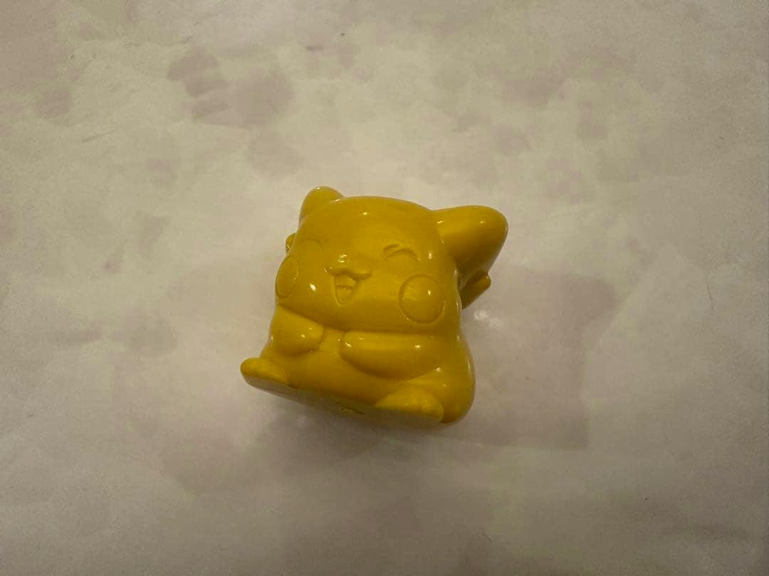 Yellow plastic Pikachu figure (Plakoro) photographed on a plain light background.