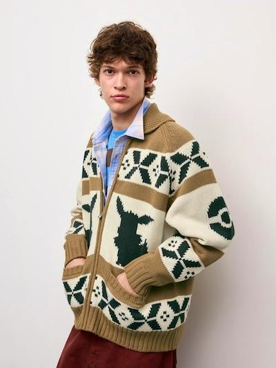 Model wearing a beige and green full-zip knit Pokémon jacket with front pockets.