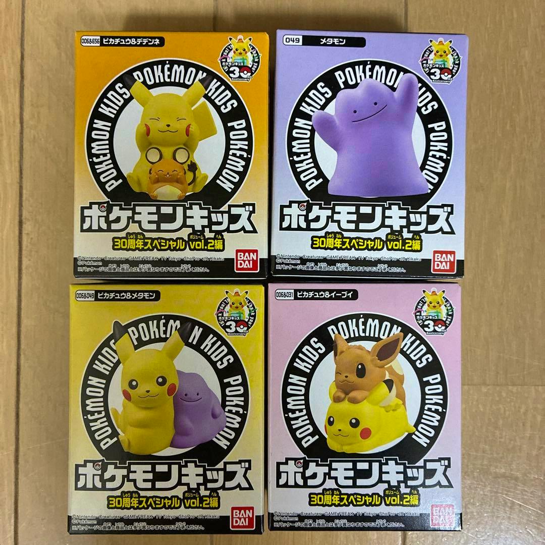 Four boxed Pokémon Kids 30th Anniversary vol.2 plastic figure packages arranged in a 2×2 grid on a wooden surface.