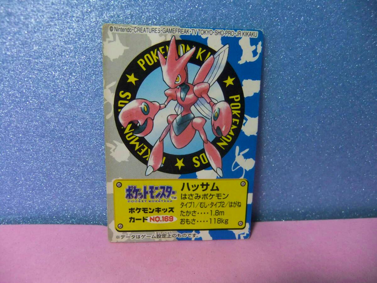 Front of a Pokémon Kids trading card (No.169 ハッサム) showing the Scizor illustration and a yellow information box.
