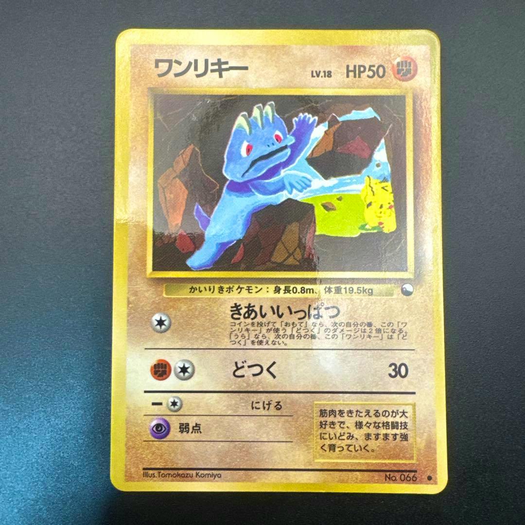 Front of a Japanese ワンリキー trading card showing the card artwork, text, and stats on a dark background.
