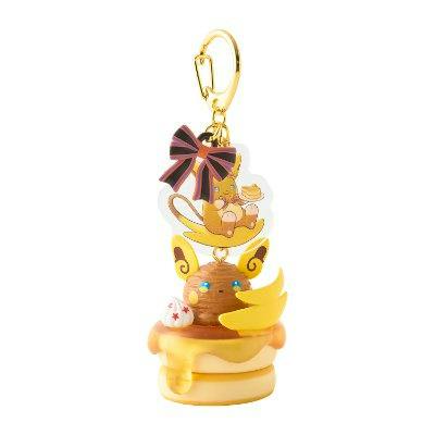 A keychain figure of Alolan Raichu on a dessert-themed base with a ribbon and gold clasp.