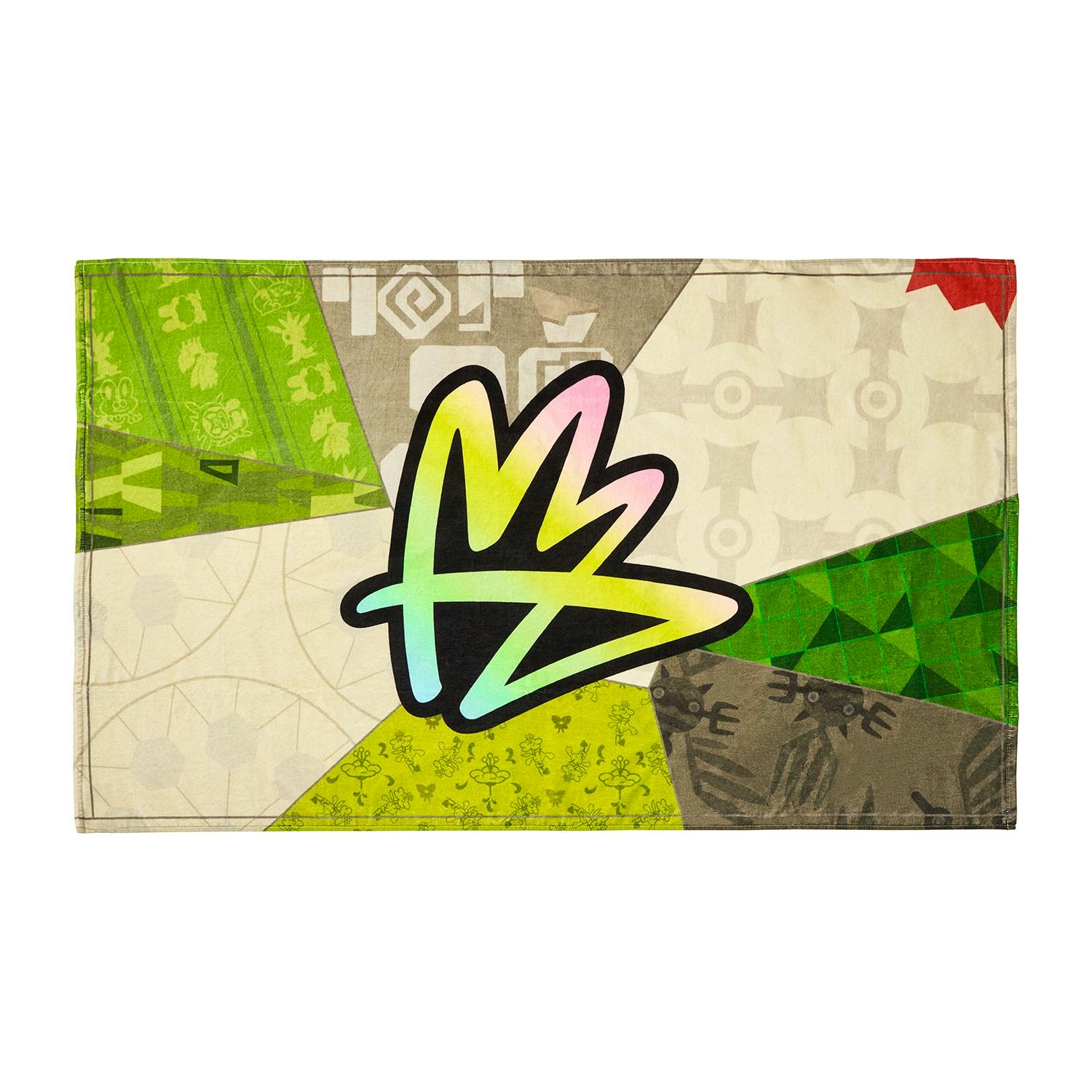A rectangular cotton hand towel with multicolored geometric panels and a large stylized graffiti-like emblem in the center.