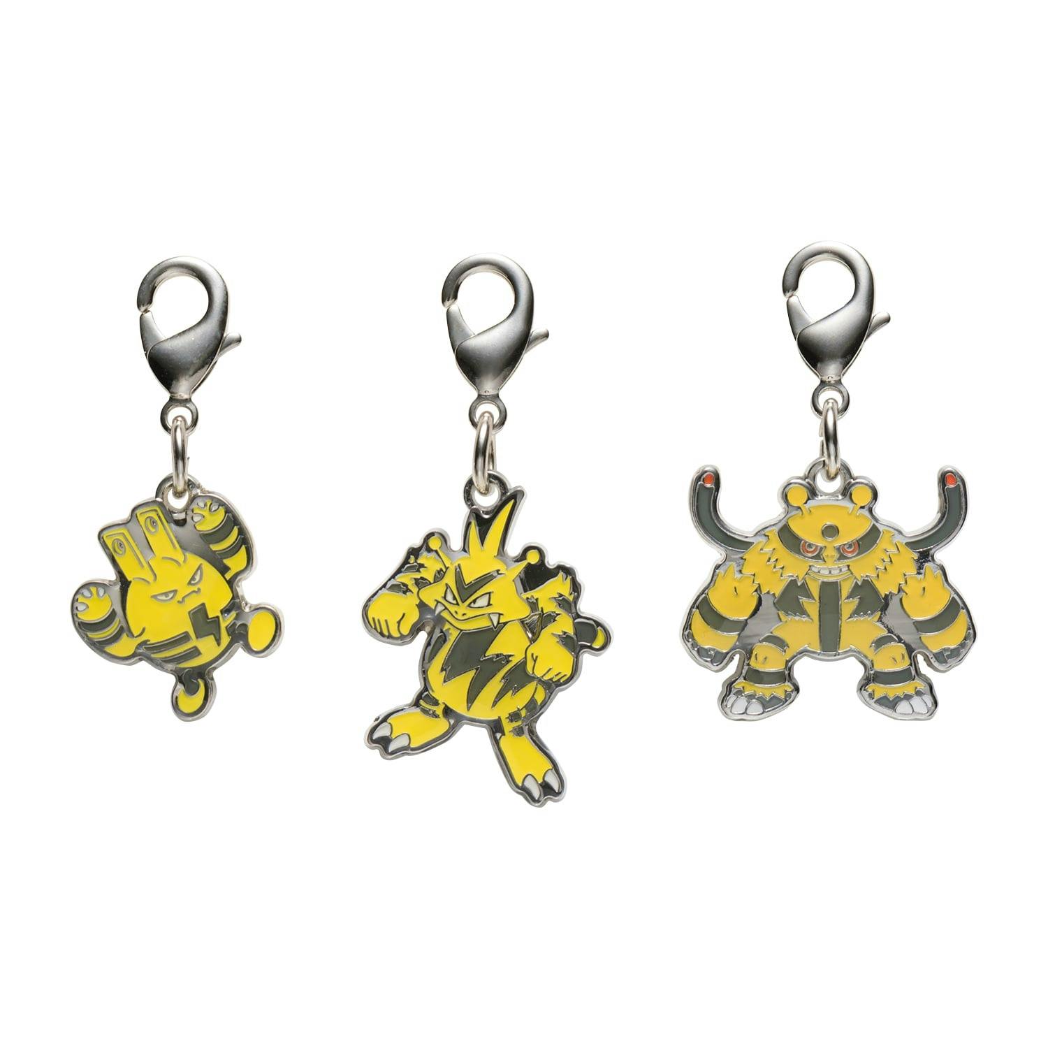 Three yellow-and-silver metal bag charms with lobster clasps shown on a white background.