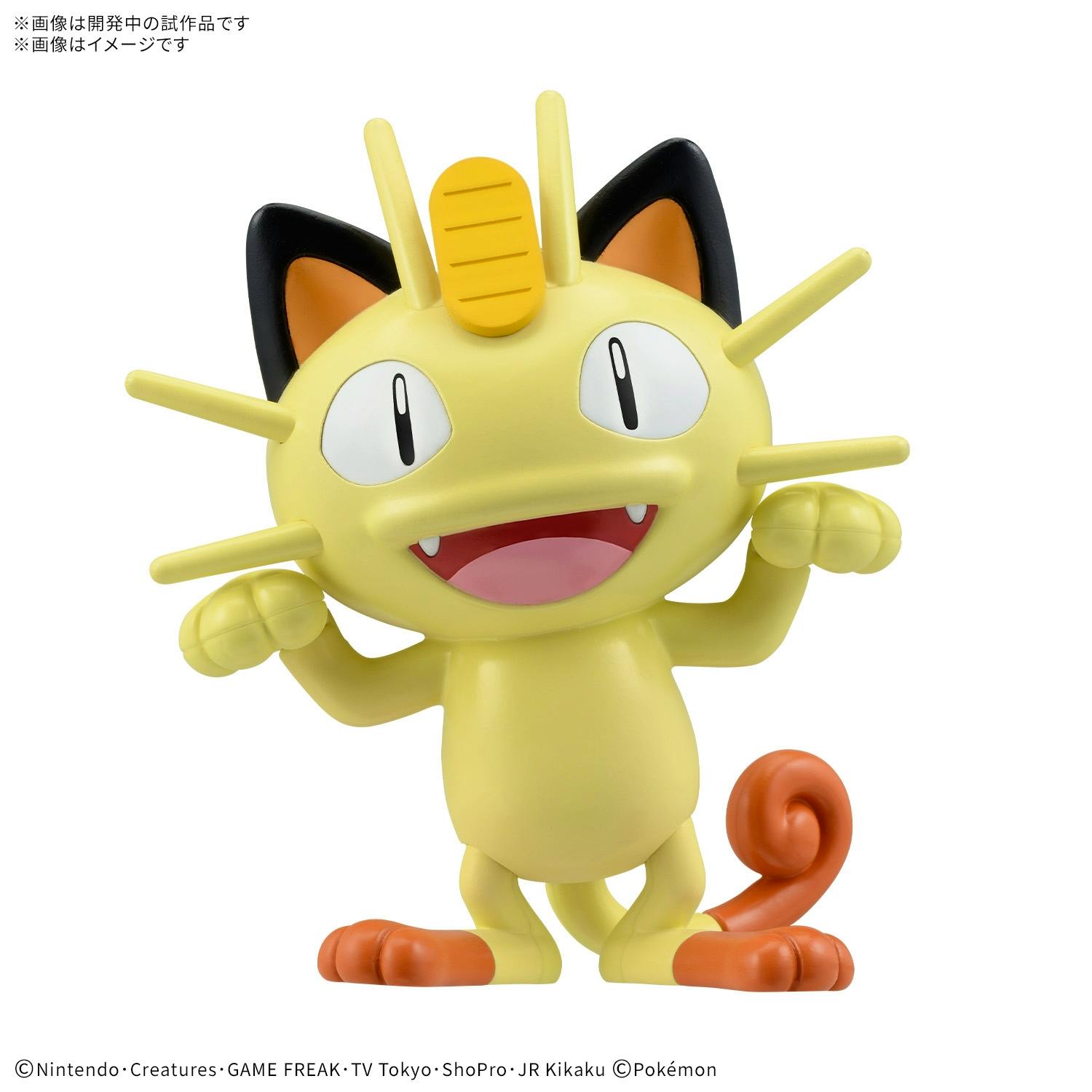 Close-up photo of a yellow Meowth plastic figure (Pokémon model) on a white background.