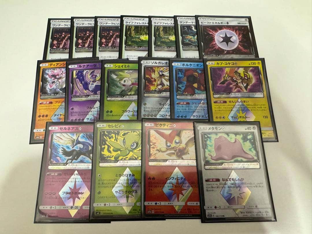 Multiple PR Prism Star Pokémon trading cards, including Metamon (Ditto), Victini, Celebi, and Xerneas, arranged on a light surface.