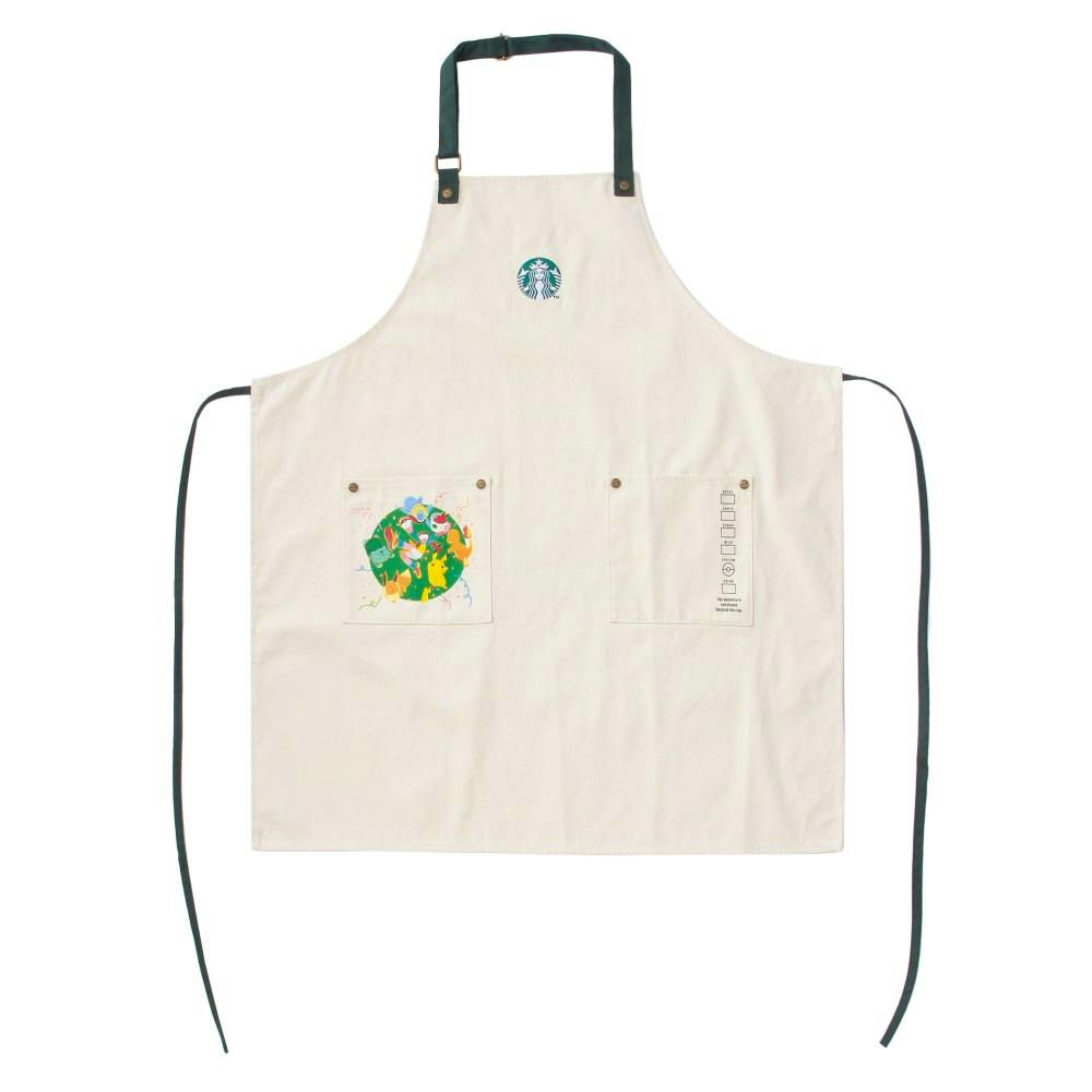 Front view of the cotton Pokémon + STARBUCKS utility apron showing the Starbucks logo at the chest, dark green neck strap, two front pockets with Pokémon artwork on the left pocket, and long waist ties.