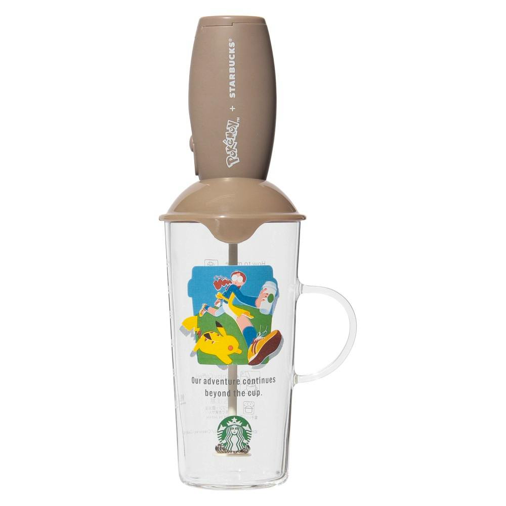 Clear plastic Starbucks cup with a Pokémon illustration and handle, topped by a brown battery-powered milk frother attachment.