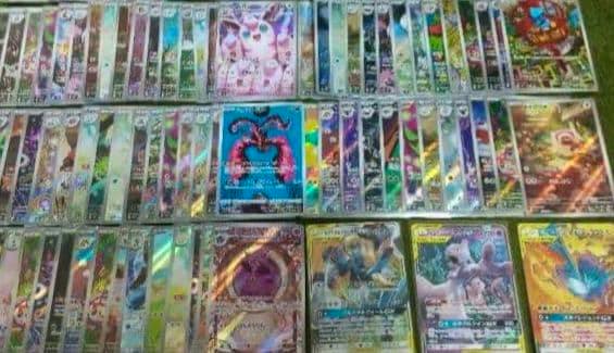 Rows of holographic Pokémon trading cards laid out on a surface, showing Tag Team GX and Mewtwo cards.