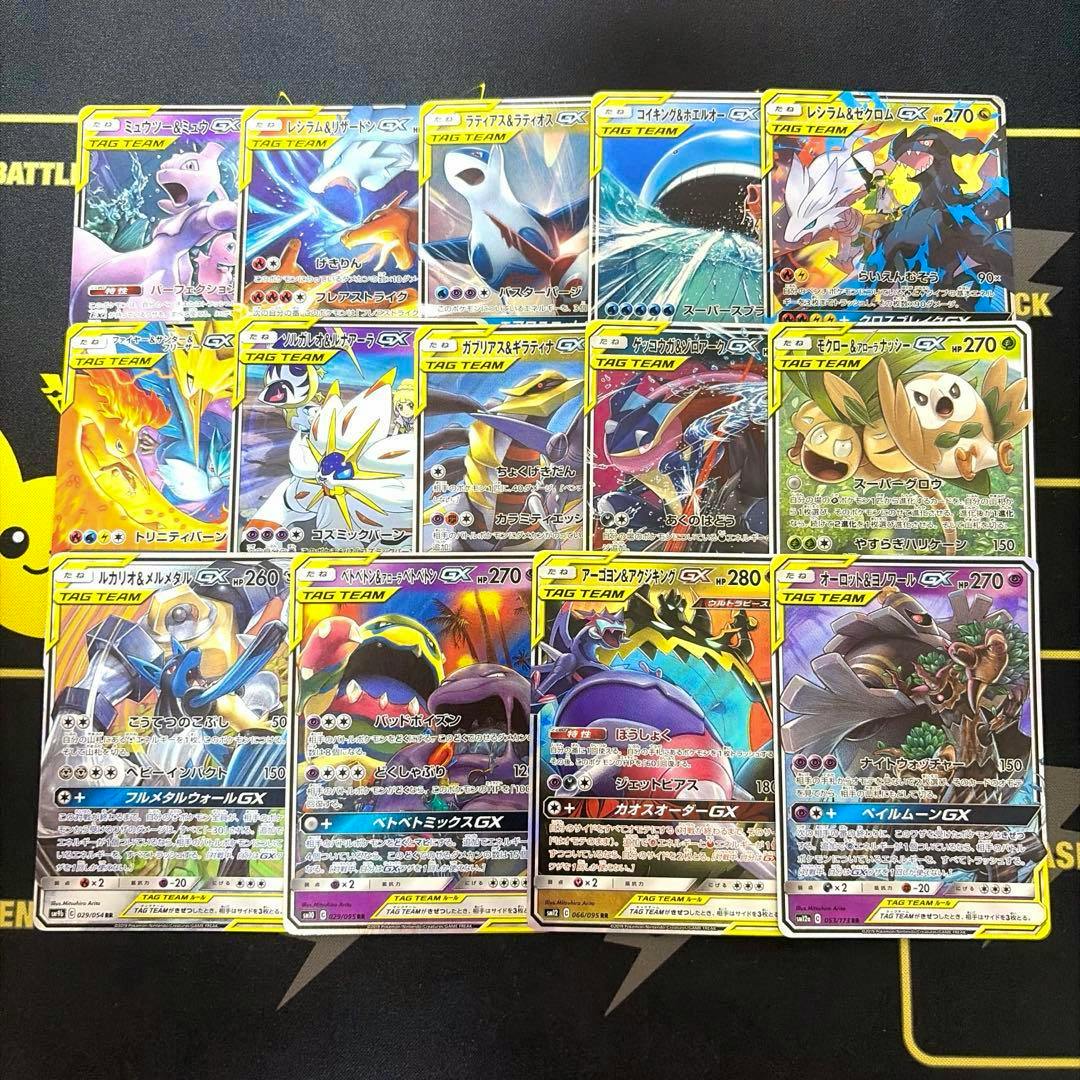 Fourteen Tag Team GX trading cards arranged in a grid on a playmat.